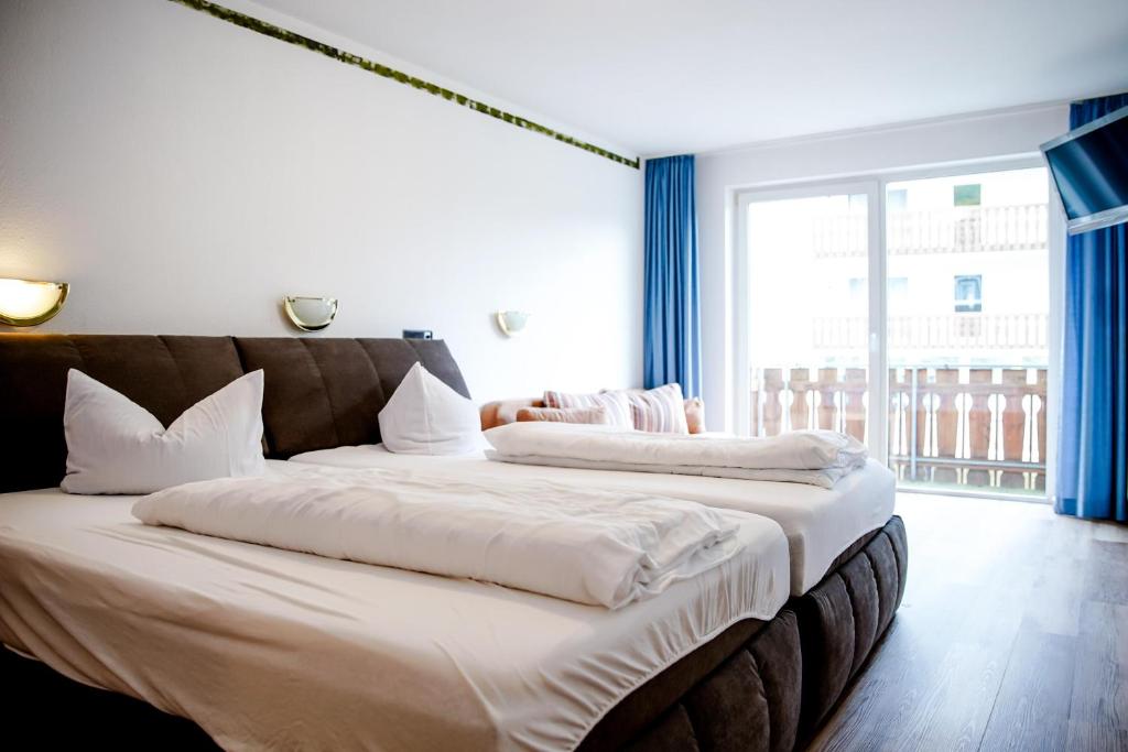 two beds in a hotel room with a large window at Smart Resorts B&B2 BB2 311 in Winterberg