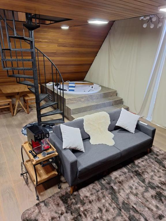 a living room with a couch and a staircase at Eros lodge in Jaboticatubas