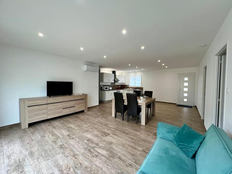 un salon avec un canapé bleu et une table dans l'établissement Ravissante maison à Abzac WIFI & Clim, à Abzac