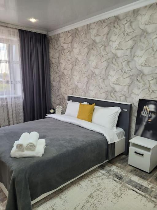 a bedroom with a bed with two towels on it at 2х ком апартаменты Район вечного огня in Kokshetau