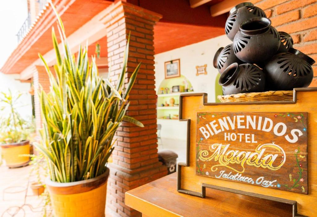 a sign in front of a hotel lobby with plants at Hotel Magda in Oaxaca City