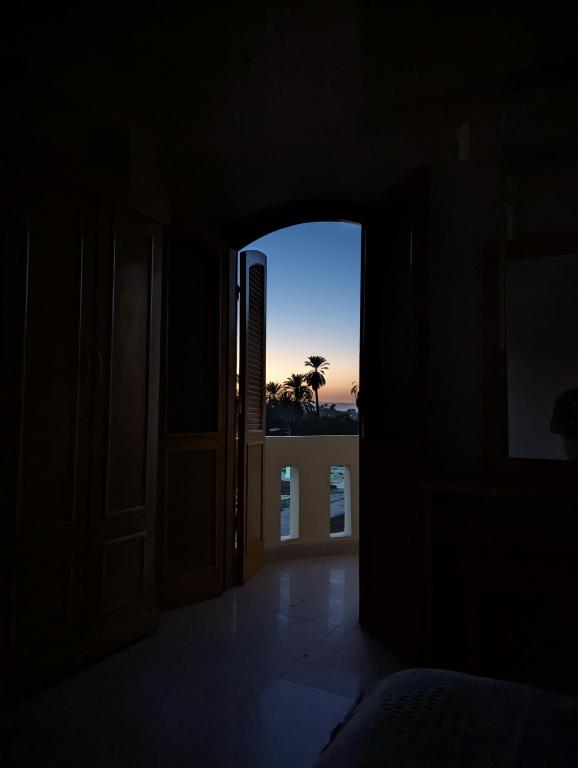 an open door to a room with a view of the sunset at Pharaohs Apartments in Luxor