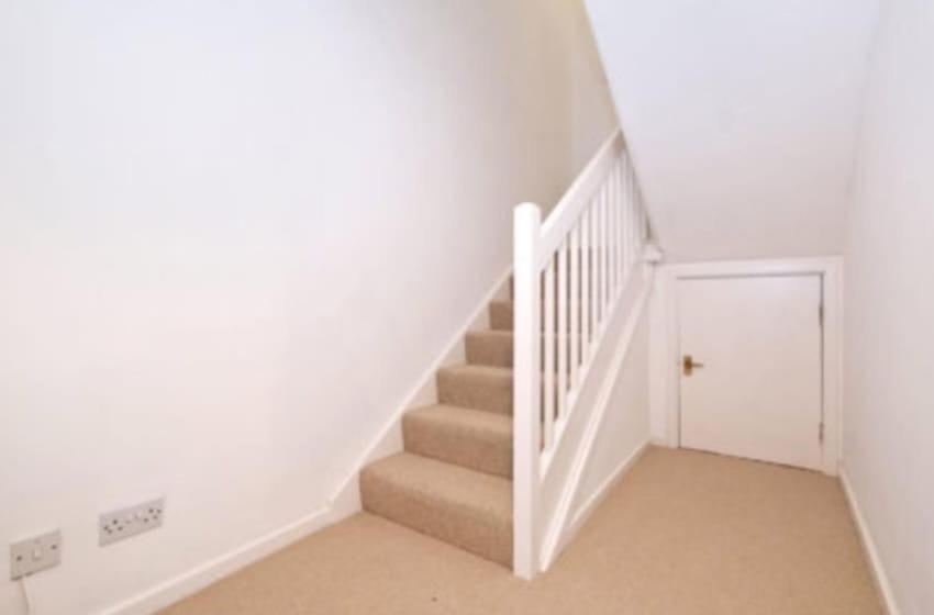 una escalera blanca en una casa con paredes blancas en Harbour view 2 weeks City centre Apt, en Aberdeen