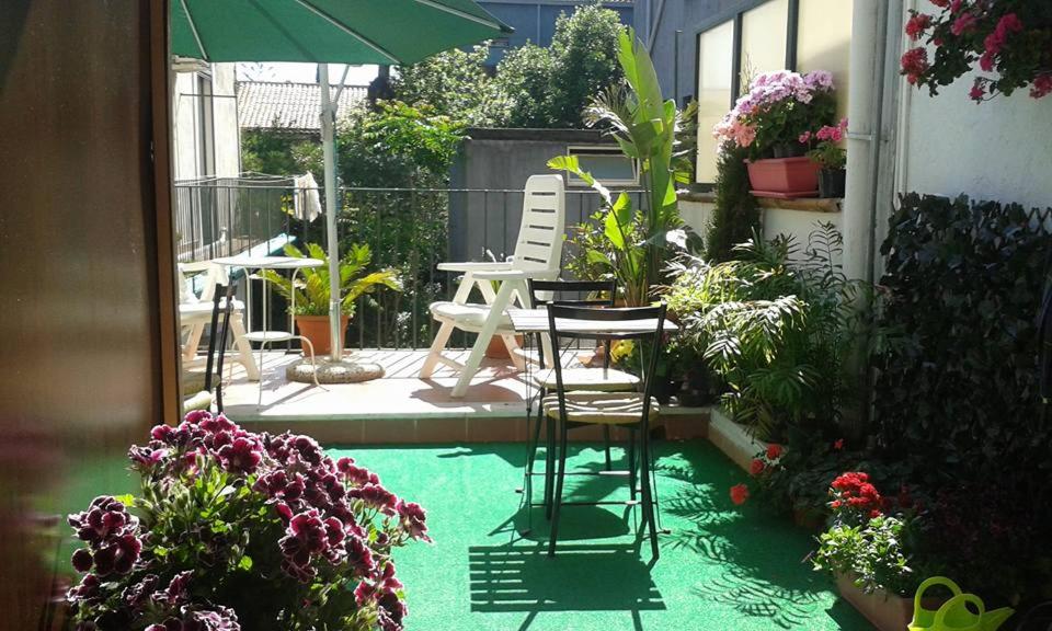 un patio con due sedie, ombrellone e piante di Piccadilly House a Catania