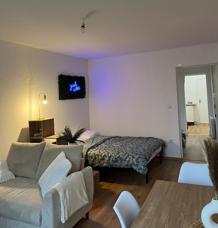 un salon avec un lit et un canapé dans l'établissement Appartement Chill & confort, à Saint-Dizier