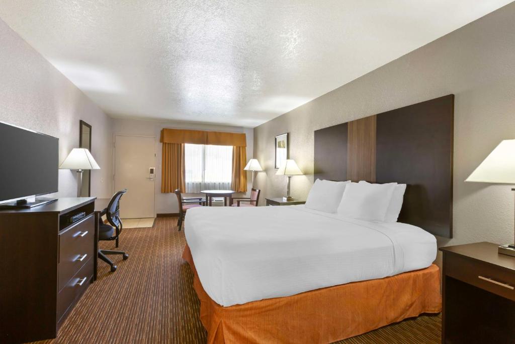 a hotel room with a large bed and a desk at Best Western Sawmill Inn in Heber