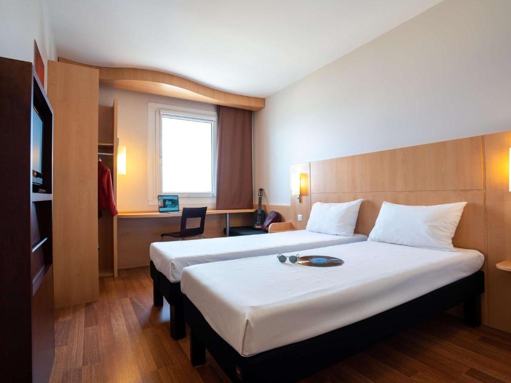 Uma cama ou camas num quarto em Ibis Hotel Plzeň