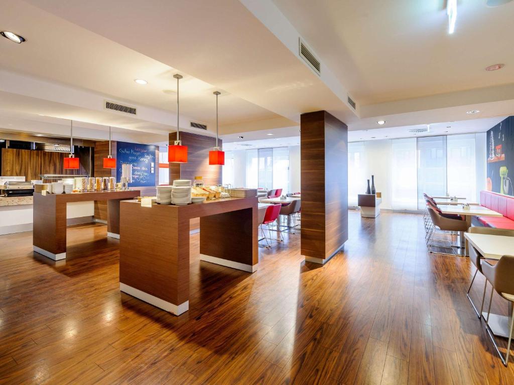 a living room with wooden floors and a dining room at ibis Stuttgart Airport Messe in Leinfelden-Echterdingen