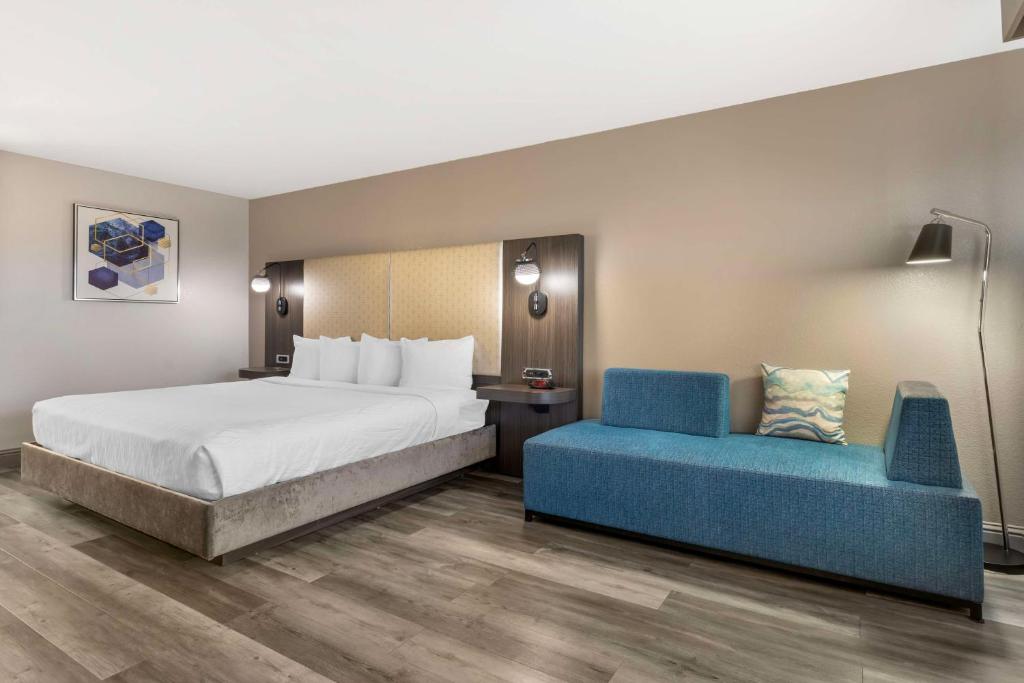 a hotel room with a bed and a blue couch at Best Western Marina State Beach in Marina