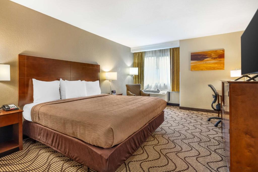 a hotel room with a large bed and a television at Best Western John Muir Inn in Martinez