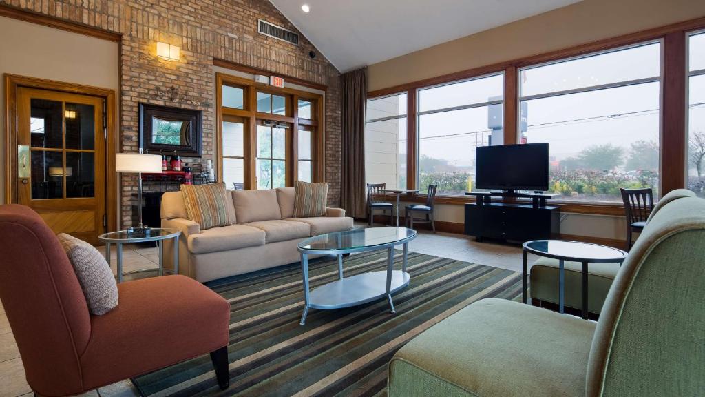Una sala de estar con un sofá y un televisor. en SureStay Plus by Best Western Covington, en Covington
