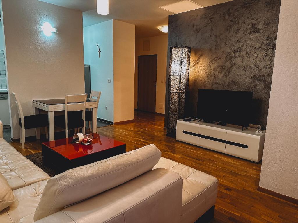 a living room with a couch and a flat screen tv at Meus Residence in Mostar