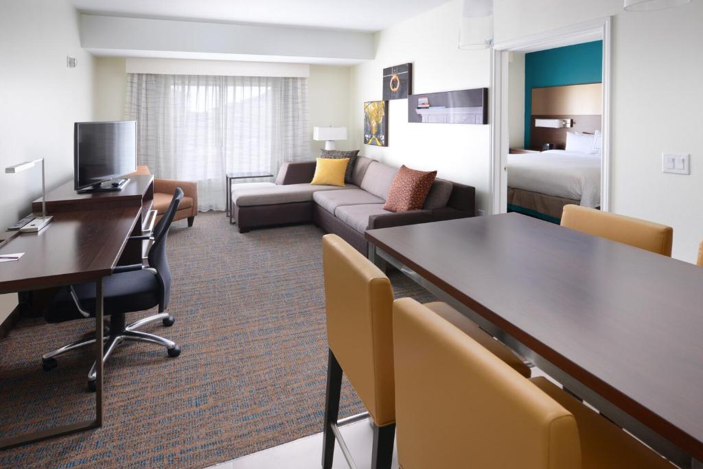 a hotel room with a desk and a living room at Residence Inn by Marriott Houston NASA/Clear Lake in Friendswood