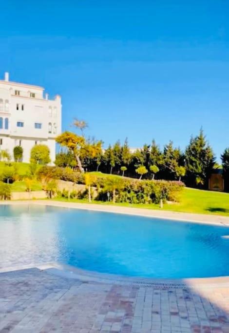 a large swimming pool in front of a building at appartement de vacances achakar plage & piscine & wifi in Tangier