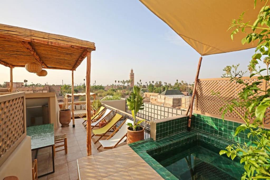 - un balcon avec une piscine au-dessus d'un bâtiment dans l'établissement Riad Ouladi -Exclusif - 5mn Jemaa El Fnaa -Pool, à Marrakech