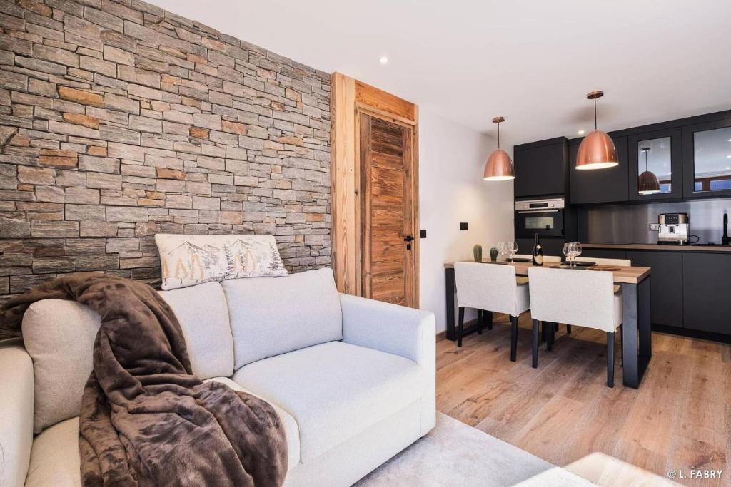 - un salon avec un canapé blanc et un mur en briques dans l'établissement Résidence Hameau Du Borsat 1& 2 - Appartement 6 personnes - Au pied des pistes MAE-2734, à Tignes