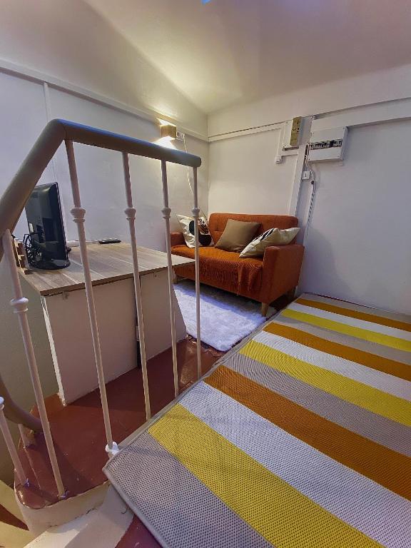 - un salon avec un canapé et une chambre dotée d'un tapis dans l'établissement Le petit change, à Avignon