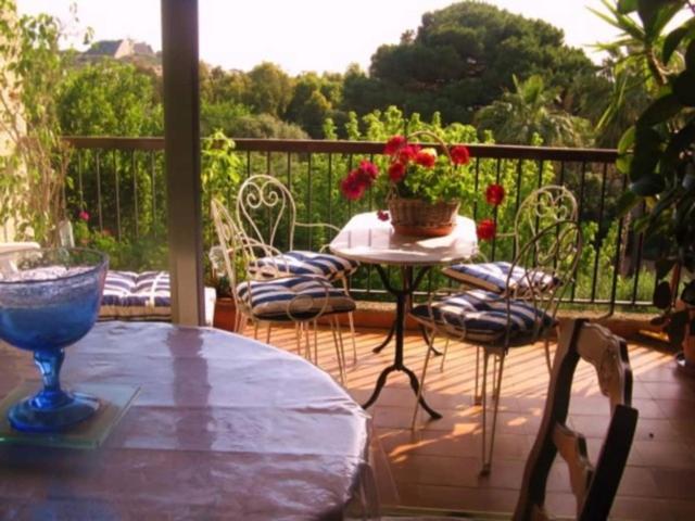 un patio avec une table et des chaises sur une terrasse dans l'établissement Lugaro, à Calvi