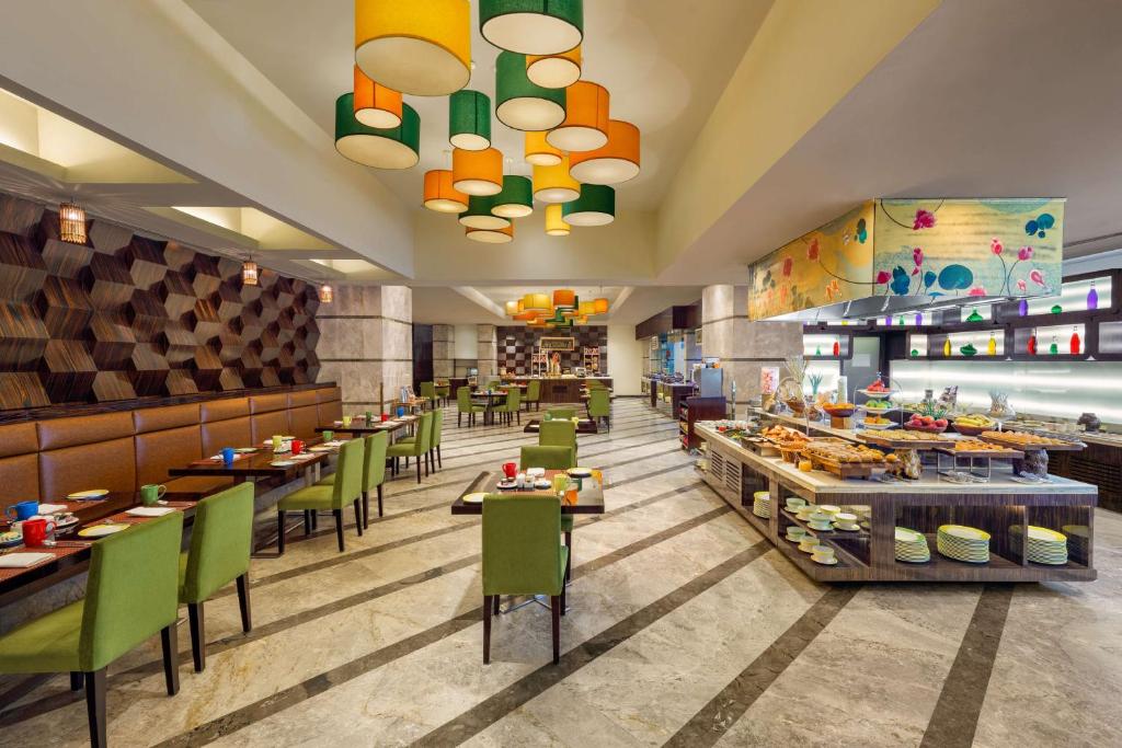 a rendering of a restaurant with tables and chairs at DoubleTree by Hilton Gurgaon New Delhi NCR in Gurgaon