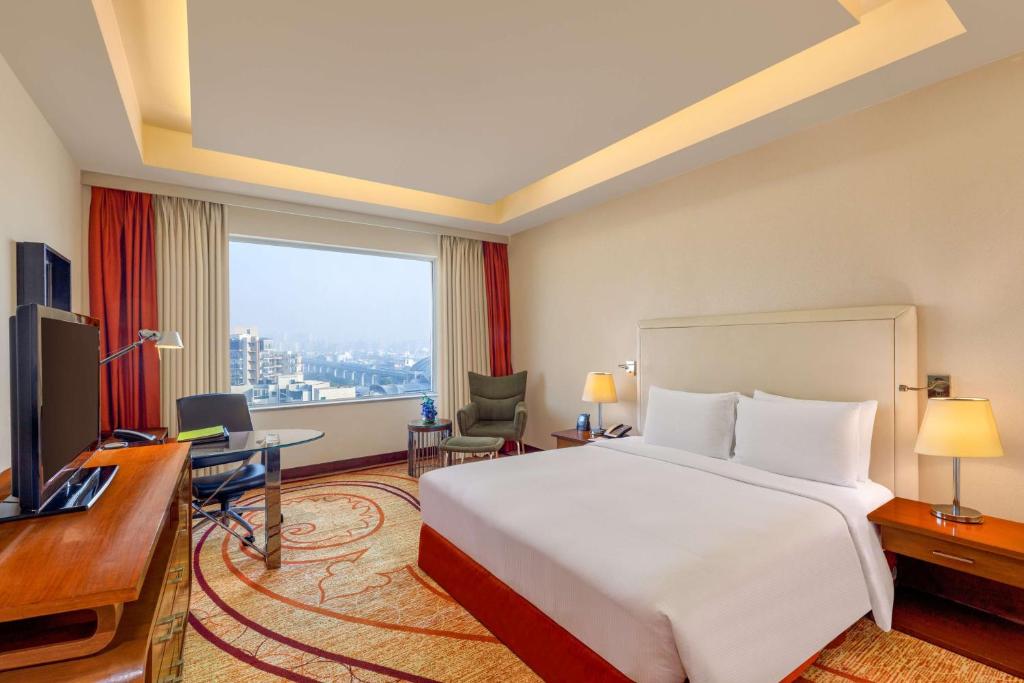 a hotel room with a large bed and a desk at DoubleTree by Hilton Gurgaon New Delhi NCR in Gurgaon