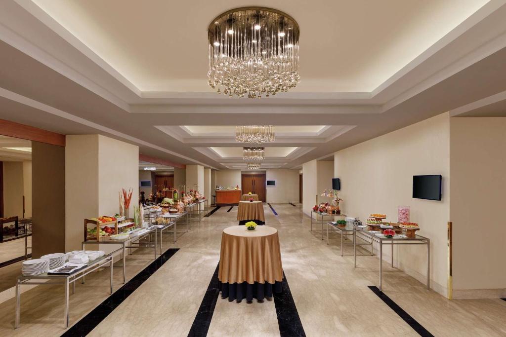 a lobby with a chandelier and a table in the middle at DoubleTree by Hilton Gurgaon New Delhi NCR in Gurgaon