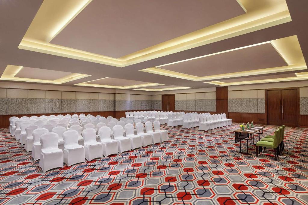 a large room with rows of white chairs and tables at DoubleTree by Hilton Gurgaon New Delhi NCR in Gurgaon