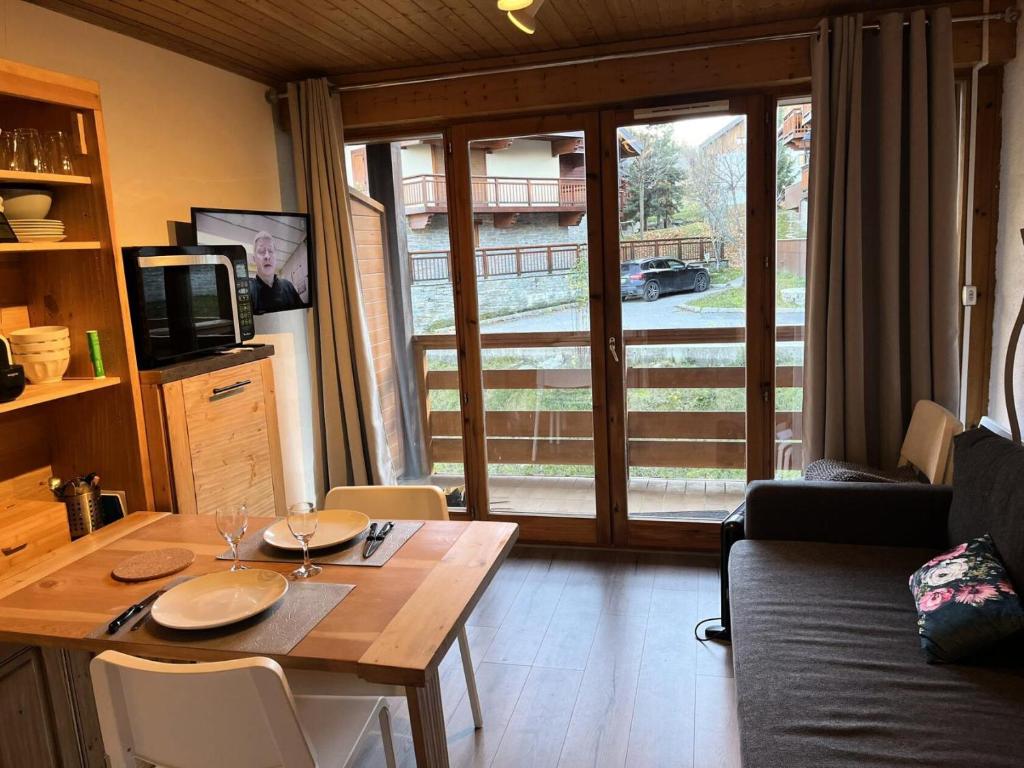 - un salon avec une table en bois et une télévision dans l'établissement Résidence Les Cordeliers - Studio 4 personnes 23pers exposé Sud MAE-3411, à Valloire