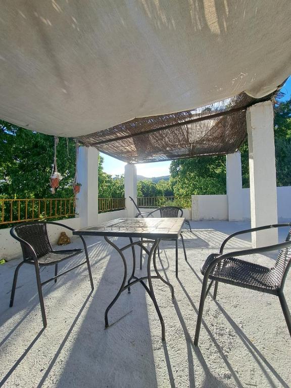 a patio with a table and chairs under a roof at LUX CASITA Almendral in Lanjarón