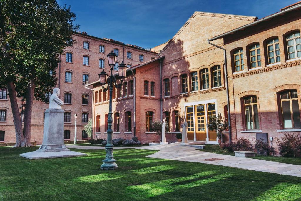 a building with a statue in the grass in front of it at Hilton Molino Stucky Venice in Venice