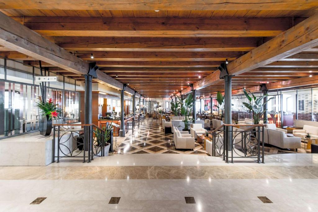 a lobby of a building with tables and chairs at Hilton Molino Stucky Venice in Venice