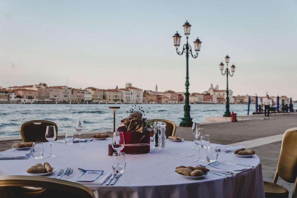 a table with plates of food and wine glasses on it at Hilton Molino Stucky Venice in Venice