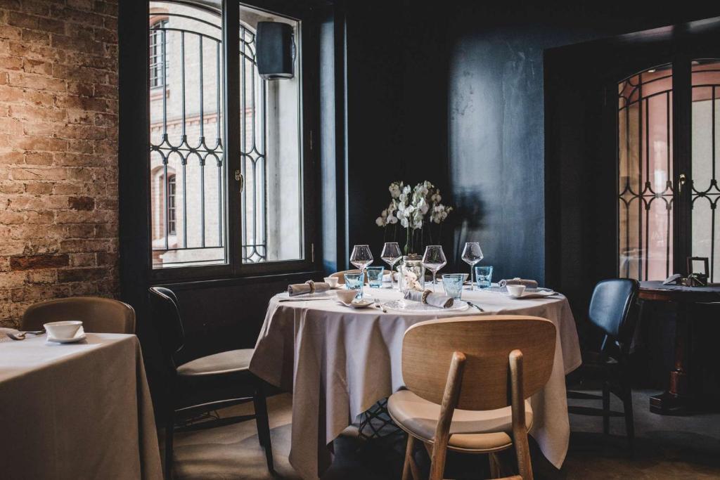 a dining room with tables and chairs and windows at Hilton Molino Stucky Venice in Venice