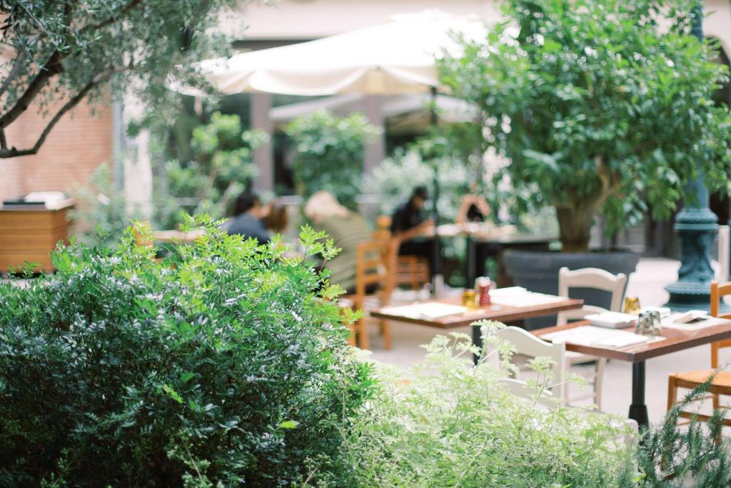 a garden with tables and chairs and people sitting at tables at Hilton Molino Stucky Venice in Venice
