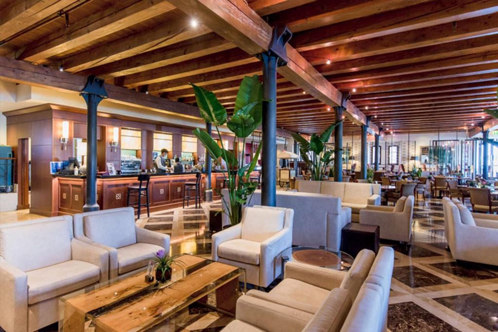 a bar with white chairs and tables in a lobby at Hilton Molino Stucky Venice in Venice
