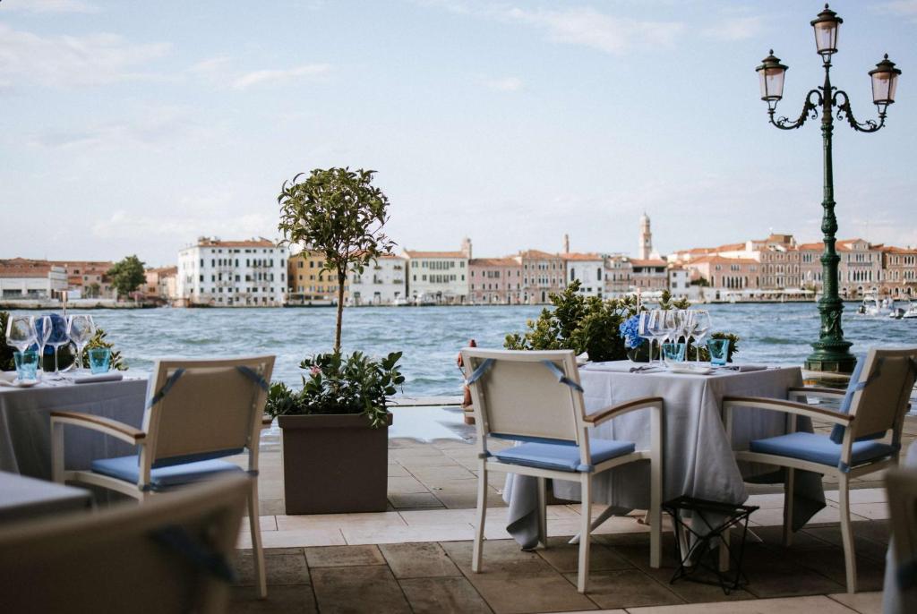 a table with chairs and a view of the water at Hilton Molino Stucky Venice in Venice