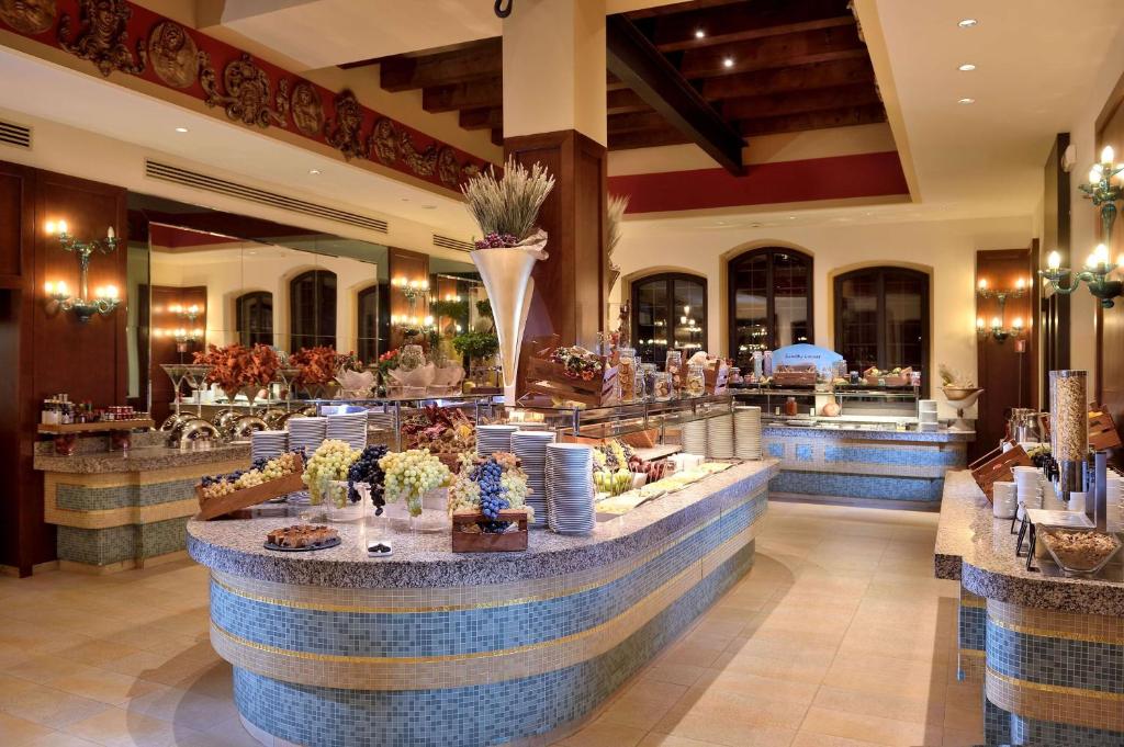 a lobby with a counter with flowers on it at Hilton Molino Stucky Venice in Venice