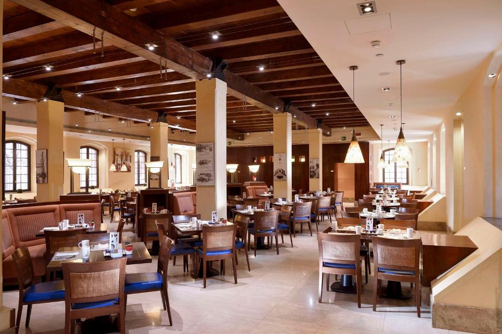 a dining room with tables and chairs in a restaurant at Hilton Molino Stucky Venice in Venice