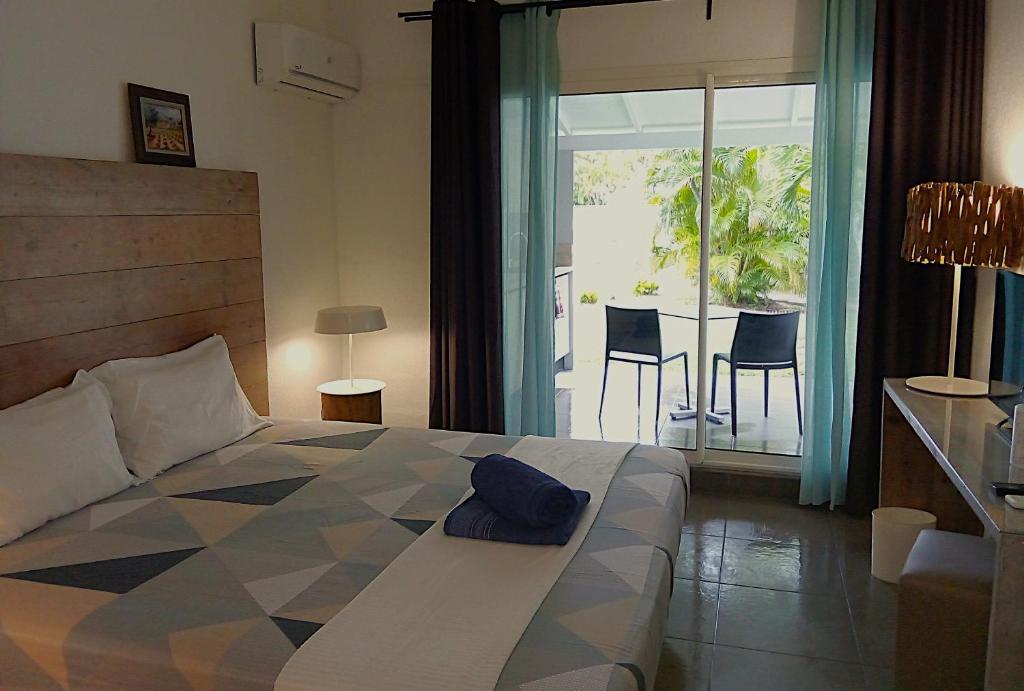 a bedroom with a bed and a view of a patio at Karukéra in Saint-François