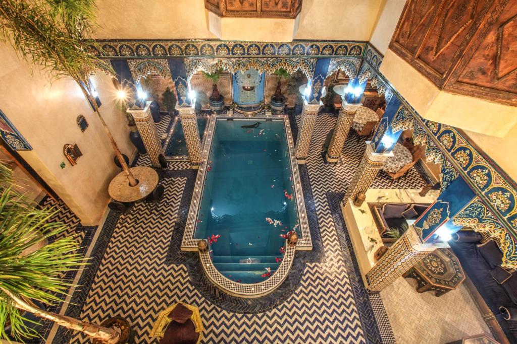 a bath room with a large tub and a large mirror at Riad Puchka in Marrakesh