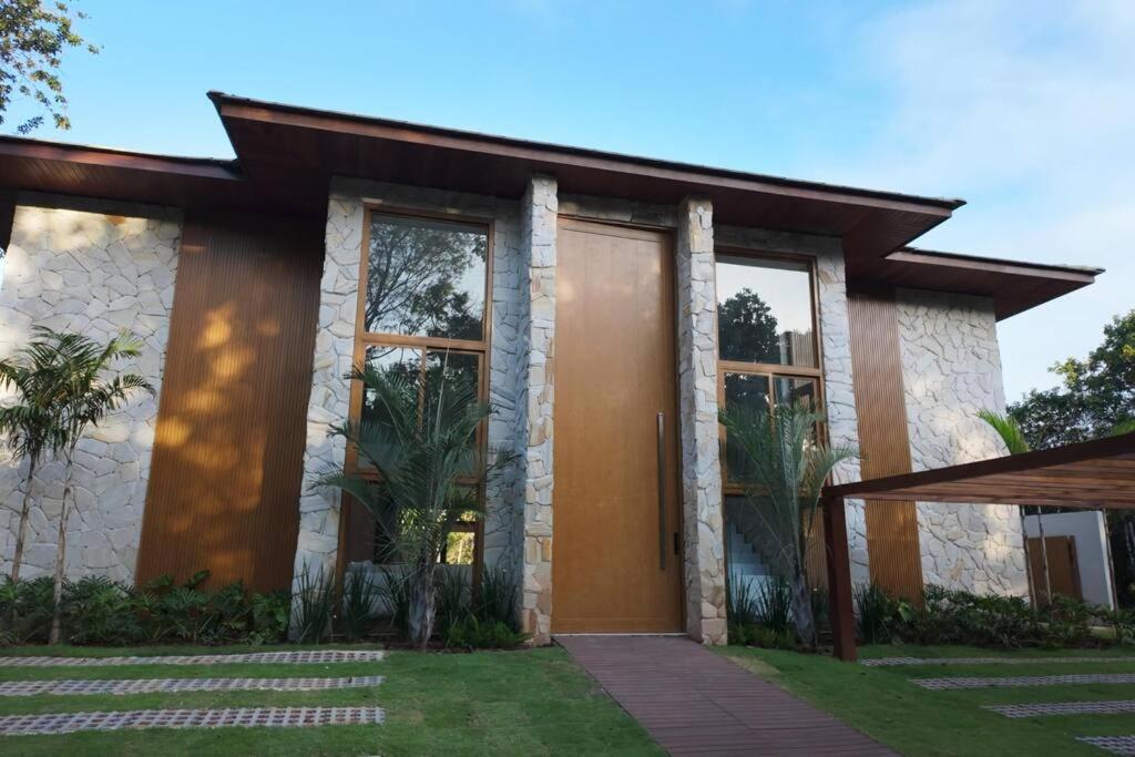 una casa con porta marrone e finestre di Casa do Castelo - Praia do Forte a Mata de Sao Joao