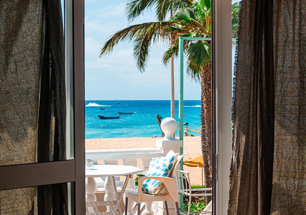 a room with a view of the beach and the ocean at Vista Mar - Seafront Holiday Apartments in Santa Maria