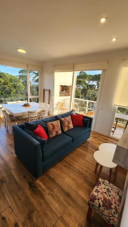 a living room with a blue couch and a table at Departamento Pinamar Centro Status Tower in Pinamar