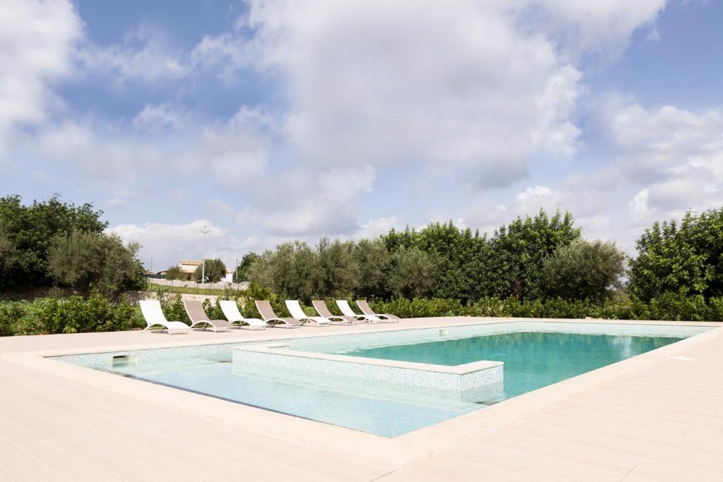 a swimming pool with chaise lounge chairs and a pool at Tre Balate Natura e Relax in Modica