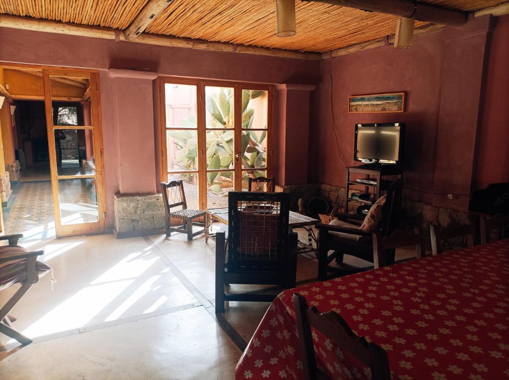 a room with a table and chairs and a tv at La Elegida in Tilcara