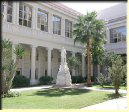 a statue in front of a building with a palm tree at Alexander The Great Hotel in Alexandria