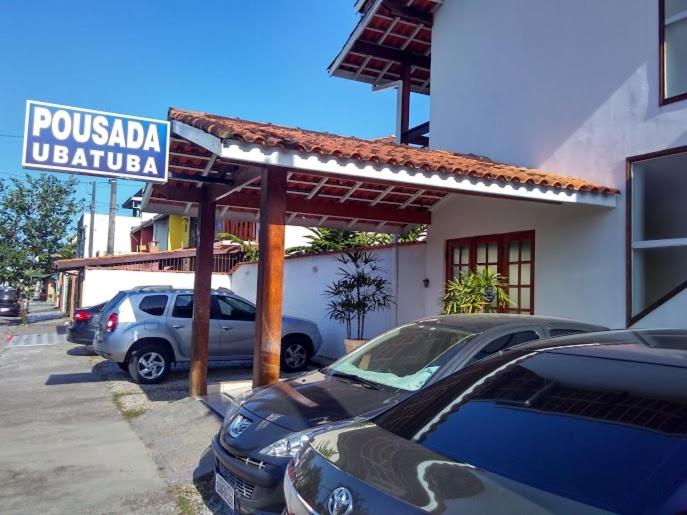 um parque de estacionamento com carros estacionados em frente a um hotel em Pousada Ubatuba Itaguá em Ubatuba