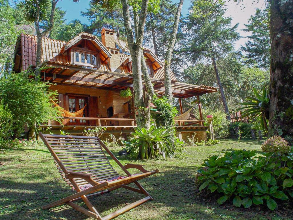 a chair sitting in front of a house at Chalés Recanto da Fonte Monte Verde - MG in Monte Verde