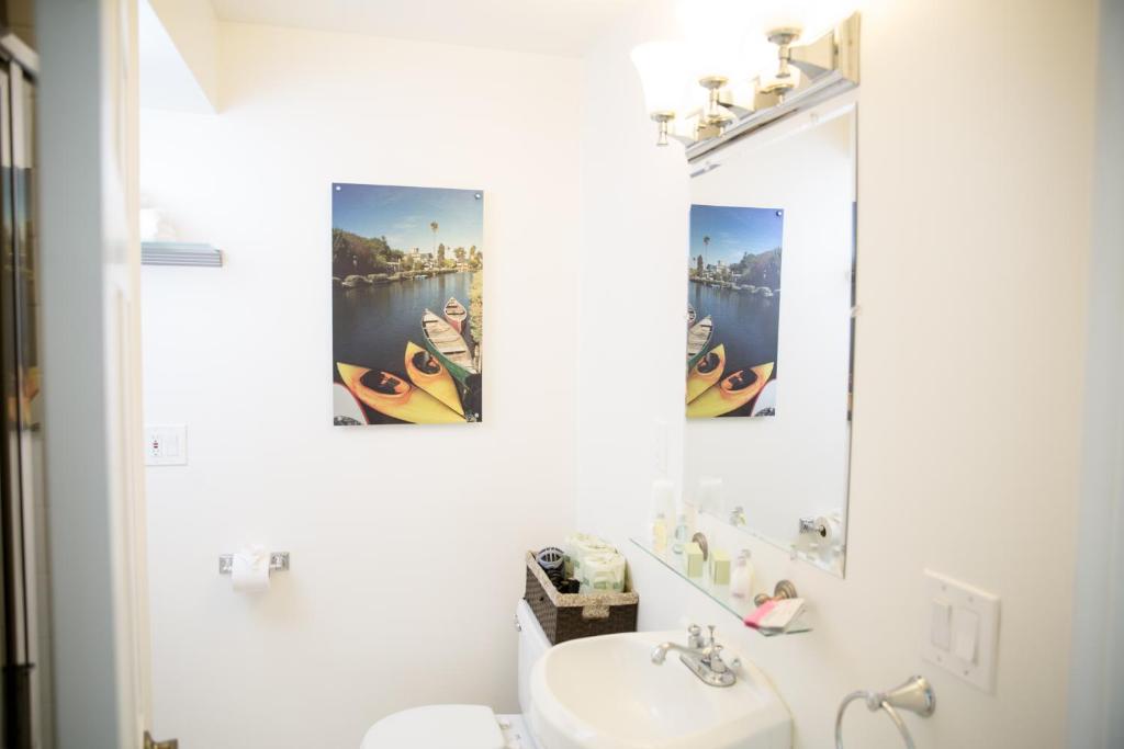 a white bathroom with a sink and a mirror at Venice on the Beach Hotel in Los Angeles