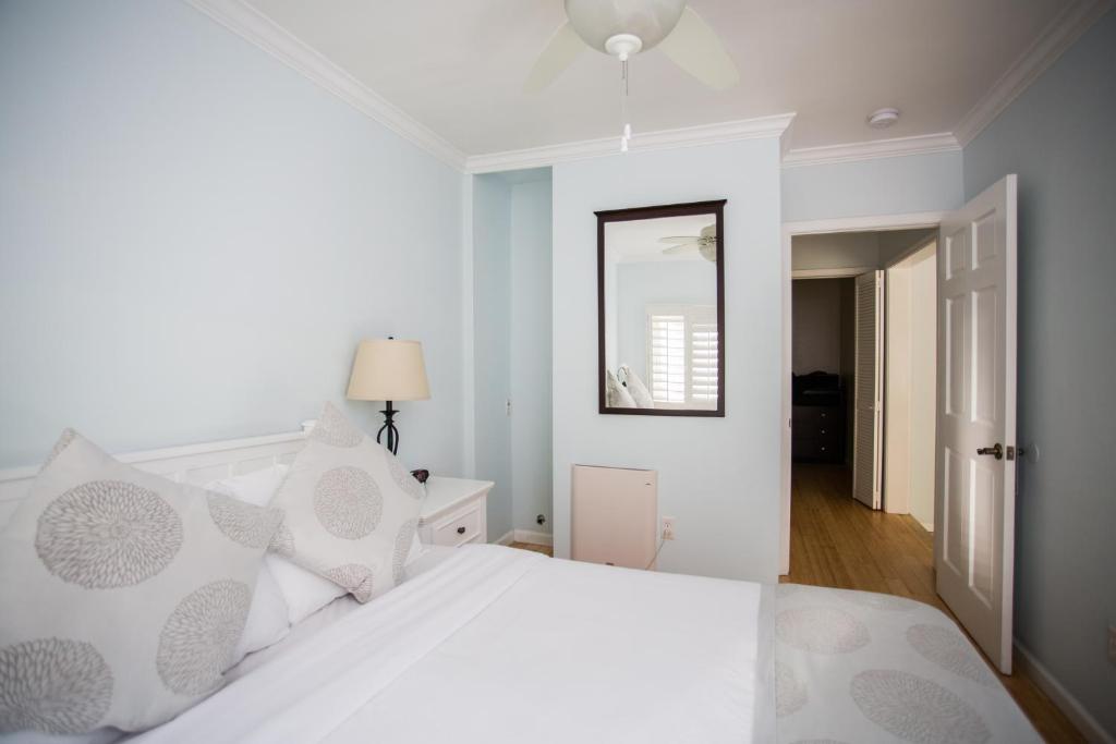 a bedroom with a white bed and a mirror at Venice on the Beach Hotel in Los Angeles