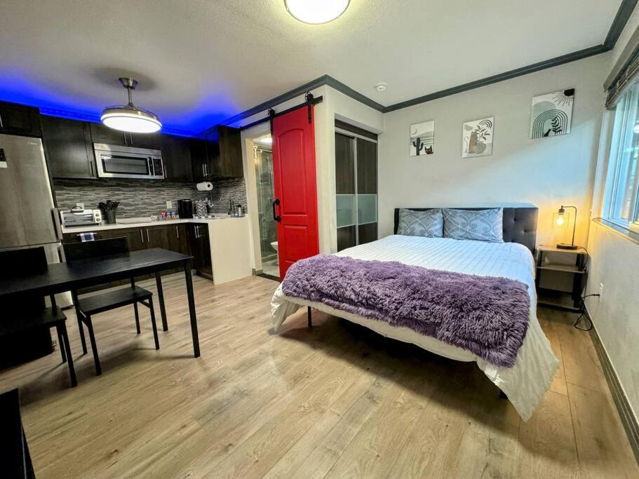 a bedroom with a bed and a desk and a kitchen at Modern condo near Fremont Street in Las Vegas